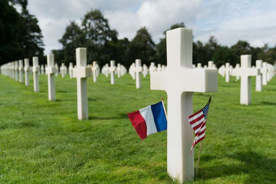 Graves at the American Cemetery at Colleville-sur-Mer with French and American flags